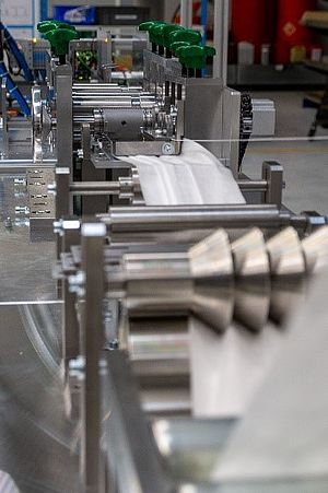 Station for folding the tissue layers of face masks